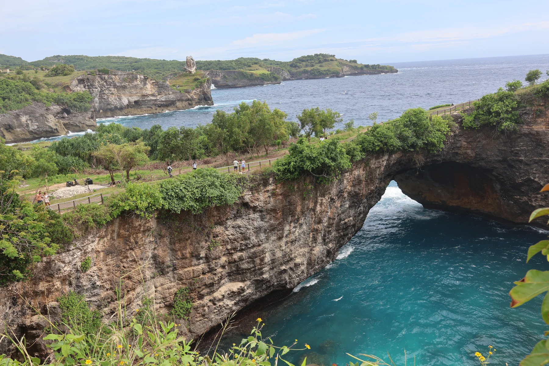 The natural rock arch at Broken Beach above blue water on Nusa Penida