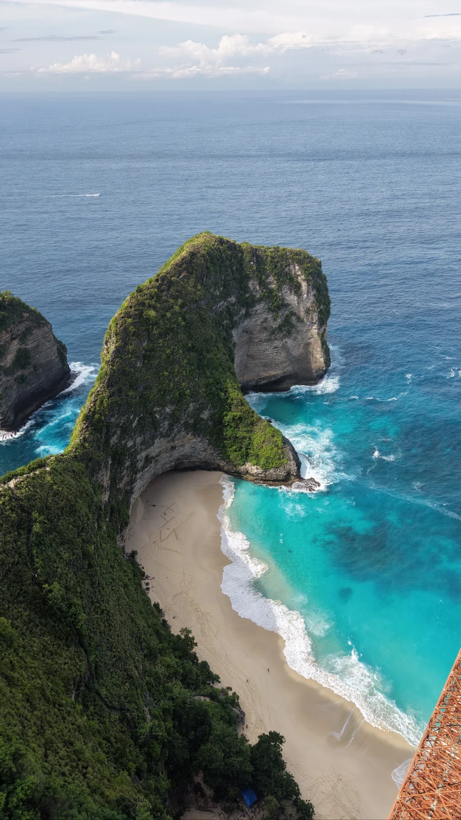 Kelingking’s green headland above a sandy beach and turquoise water