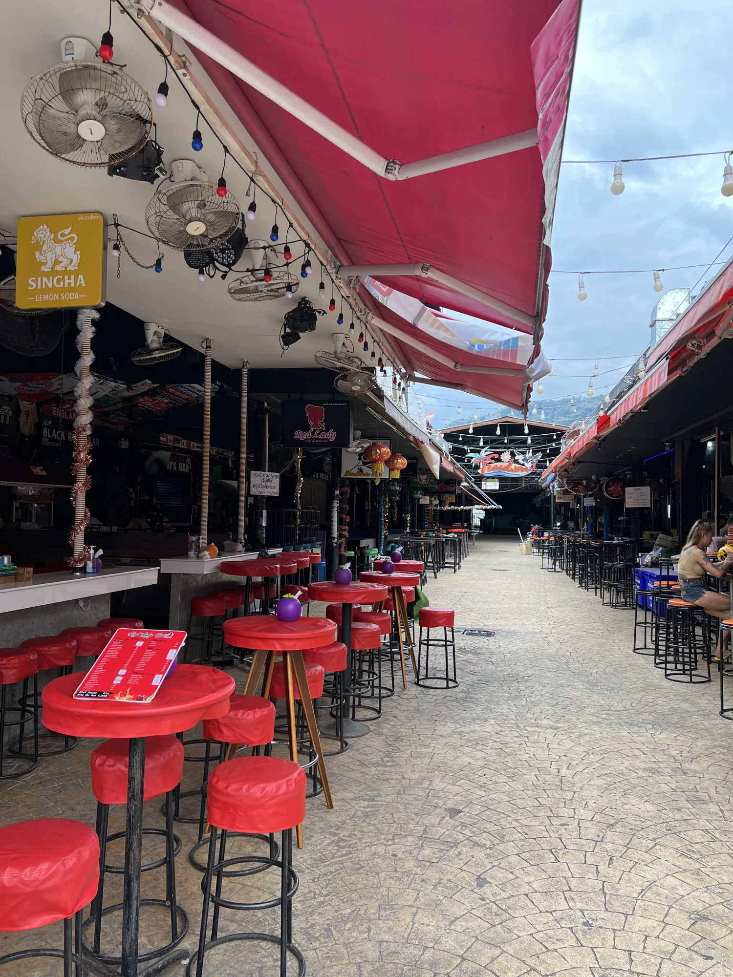 Covered bar lane with red stools in Patong