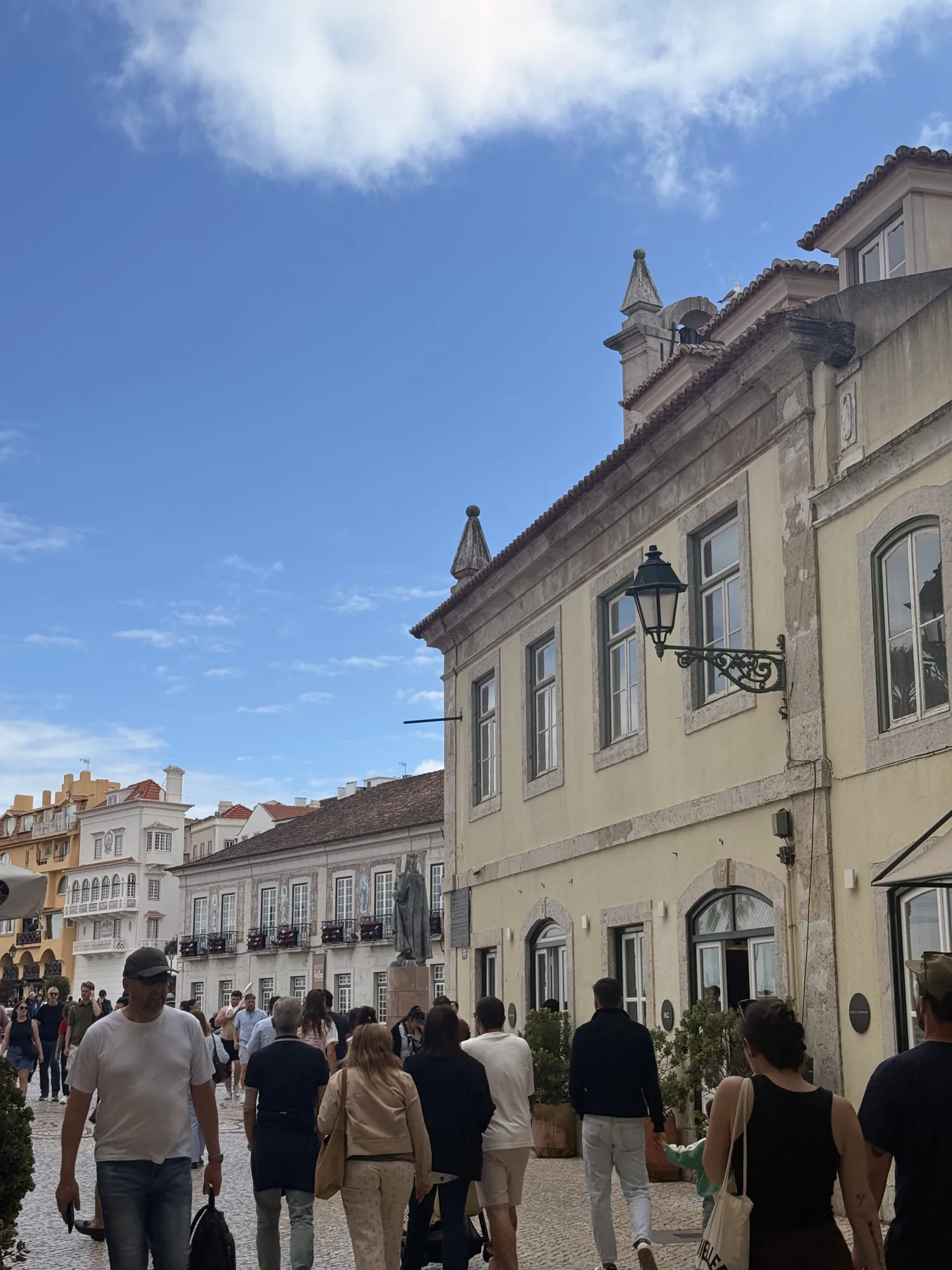Cascais town street with pale buildings and people walking