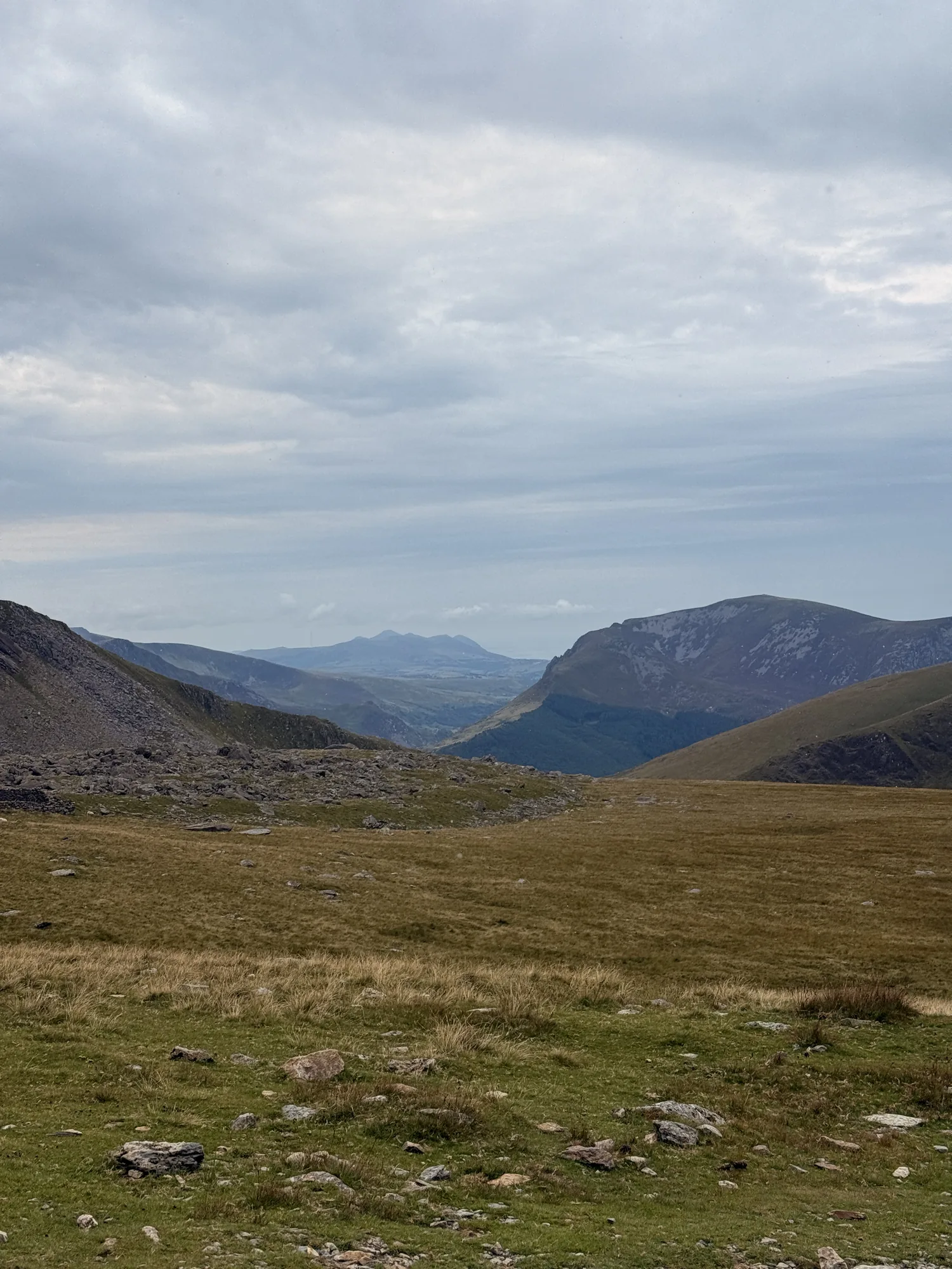 An open mountain valley and distant layered hills in Eryri.